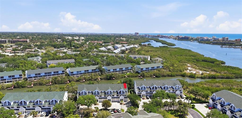 This aerial view shows a waterfront townhouse complex with green roofs and surrounding vegetation — 14837 SEMINOLE TRAIL, SEMINOLE, FL