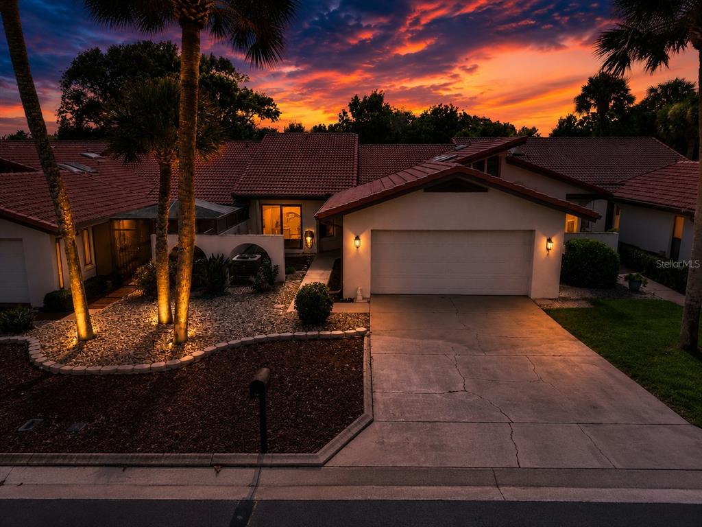 A single-story house with a white exterior, red tile roof, and a two-car garage — 503 CLUBHOUSE DRIVE, LAKE WALES, FL