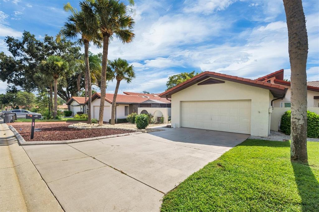 A single-story house with a tiled roof, a two-car garage, and a landscaped front yard — 503 CLUBHOUSE DRIVE, LAKE WALES, FL