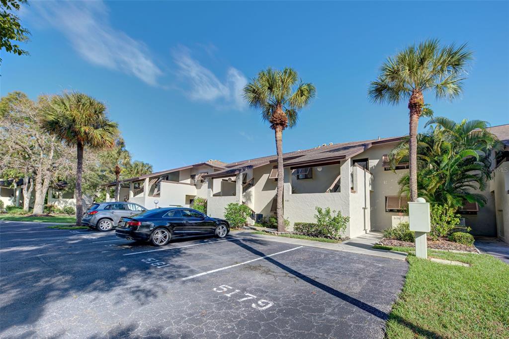 A two-story apartment building exterior with a parking lot in the foreground — 5179 WILLOW LINKS UNIT 27, SARASOTA, FL