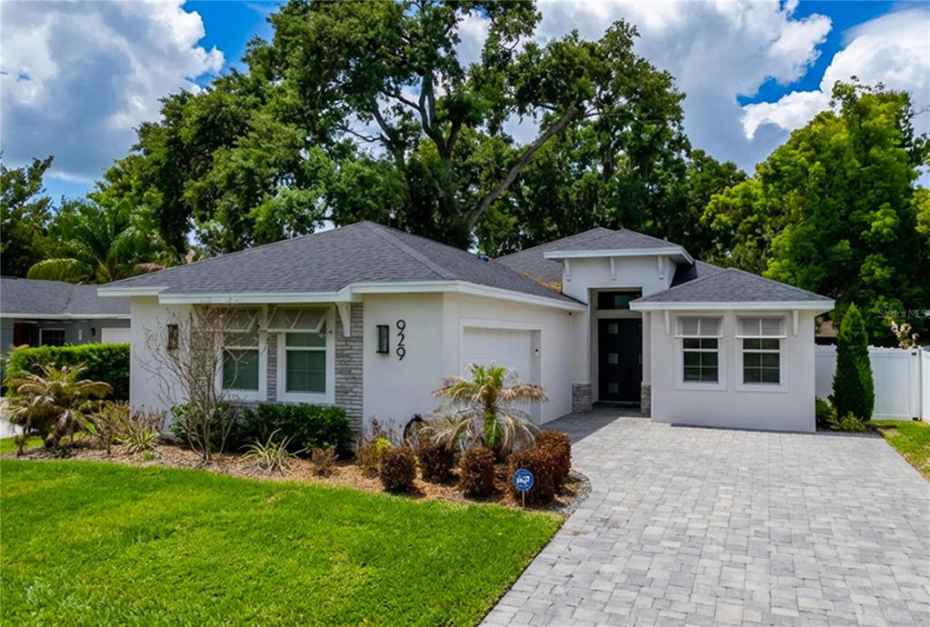 A single-story house with a paved driveway, white stucco exterior, and a dark shingled roof — 929 CLEARVIEW AVENUE, LAKELAND, FL