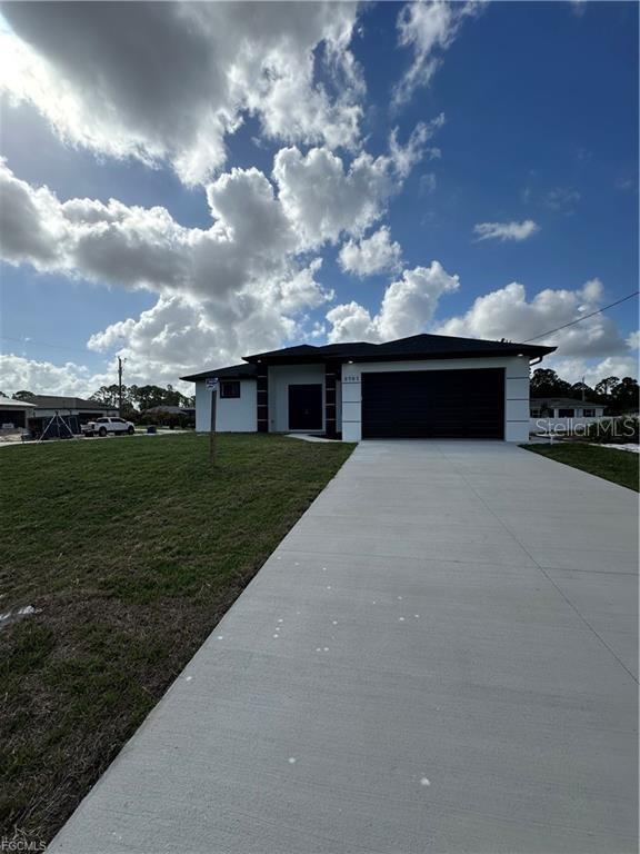 A modern single-story house with a white exterior, dark garage door, and a concrete driveway — 3701 28TH STREET SW, LEHIGH ACRES, FL