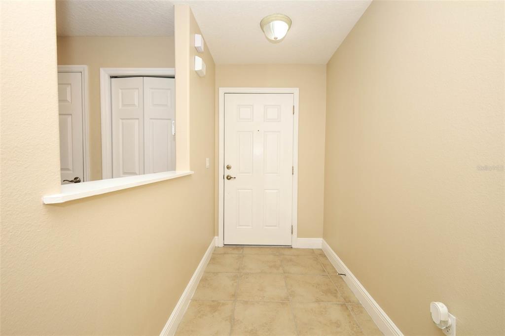 An entryway features beige walls, tile flooring, a white front door, and a wall cutout — 162 CONSTITUTION WAY, WINTER SPRINGS, FL