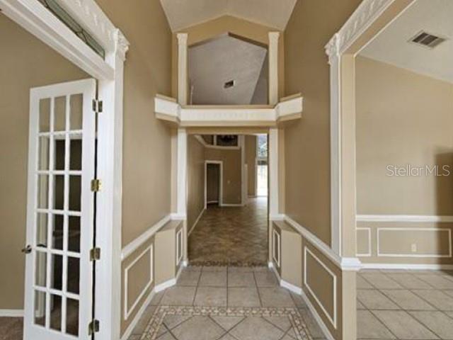 A tiled entryway features a white French door, beige walls, and decorative crown molding — 2128 LAKE CRESCENT COURT, WINDERMERE, FL