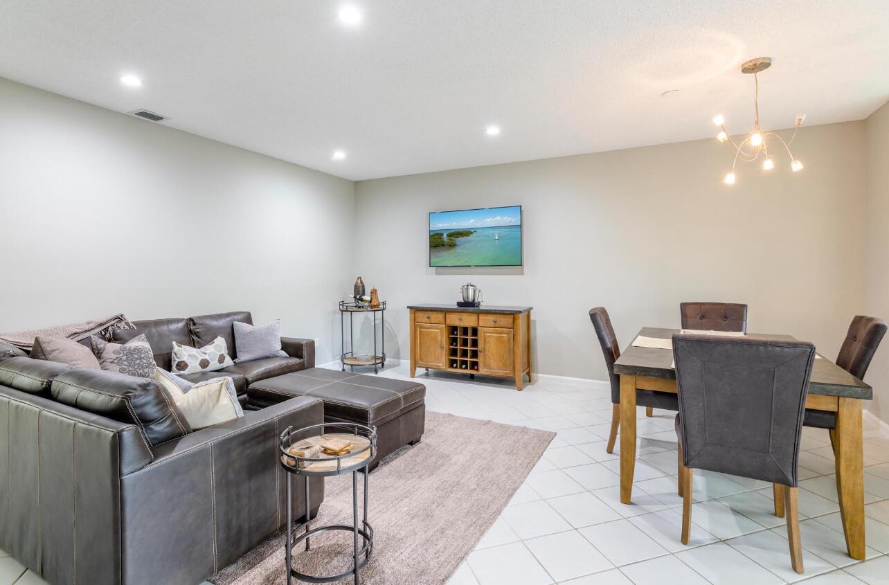 A living and dining area features a leather sectional, wooden sideboard, and a dining set — 6666 Montego Bay Boulevard, Boca Raton FL 33433, BOCA RATON, FL