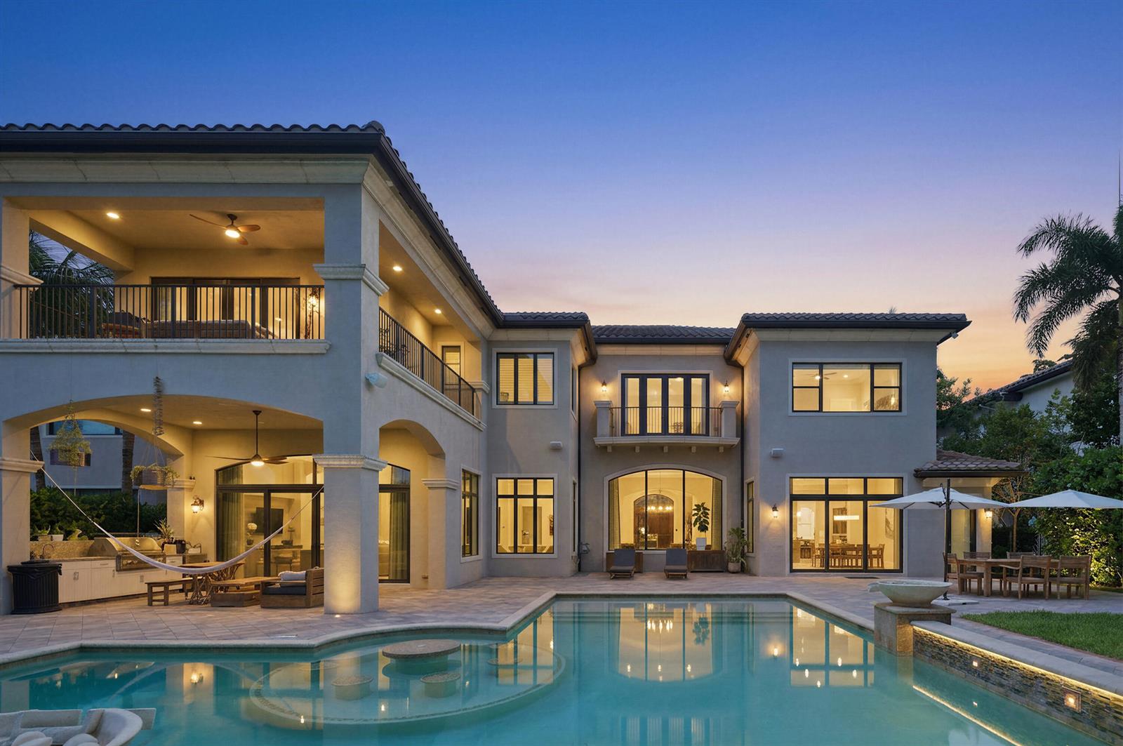 A two-story house with a pool, covered patio, and balcony at dusk — 16907 Crown Bridge Drive, Delray Beach FL 33446, DELRAY BEACH, FL