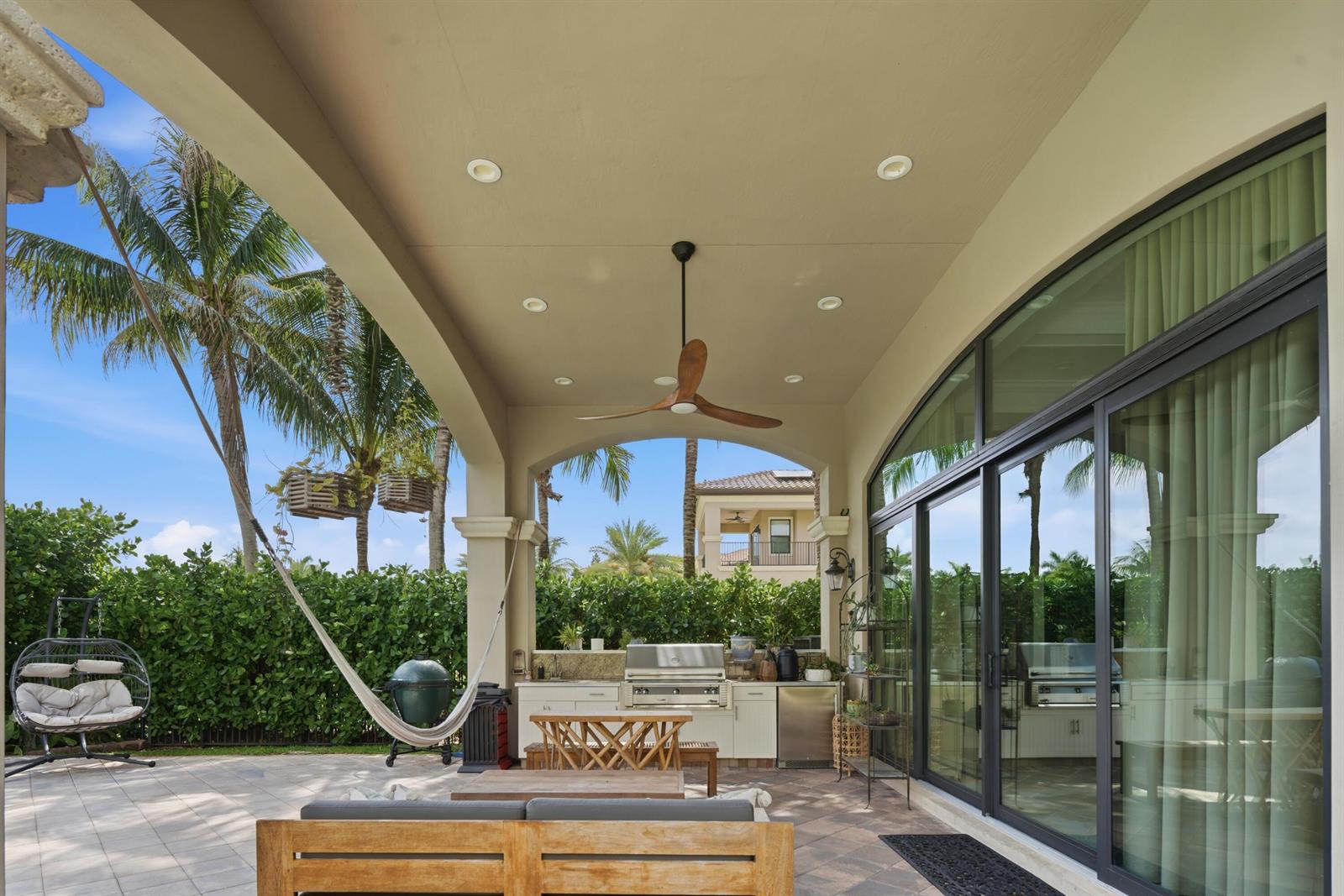 A covered outdoor patio features a built-in grill, a ceiling fan, and a hammock — 16907 Crown Bridge Drive, Delray Beach FL 33446, DELRAY BEACH, FL