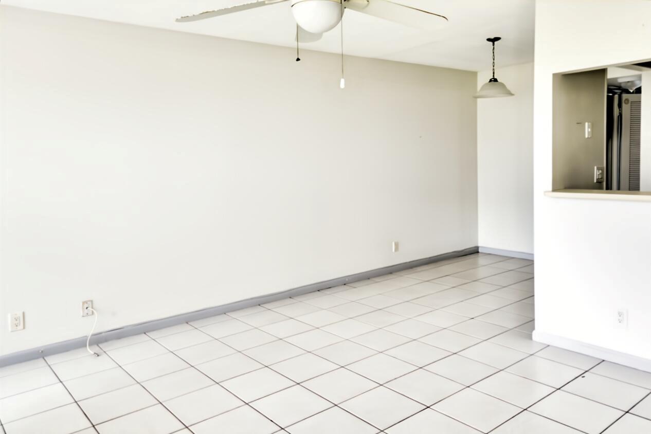 An empty room with white walls, white tile flooring, a ceiling fan, and pendant lighting — 164 Andover G, West Palm Beach FL 33417, WEST PALM BEACH, FL
