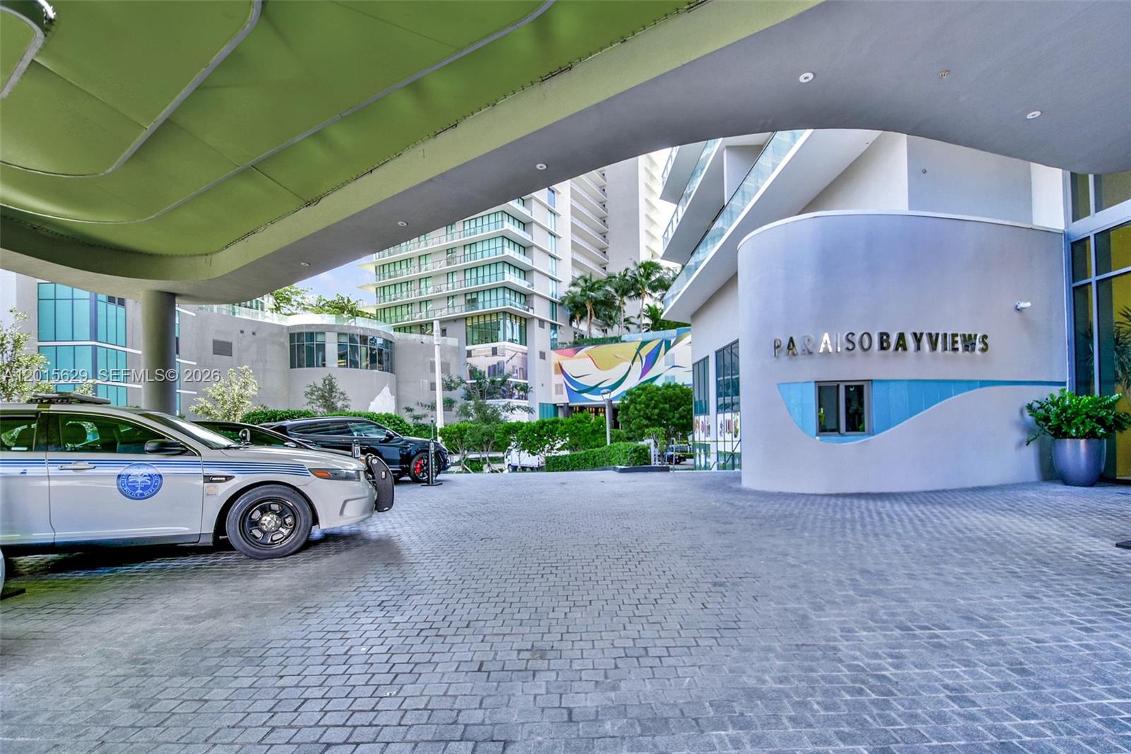 A police car is parked under the covered entrance of the Paraiso Bayviews building — 501 NE 31st St # 608, Miami FL 33137, MIAMI, FL