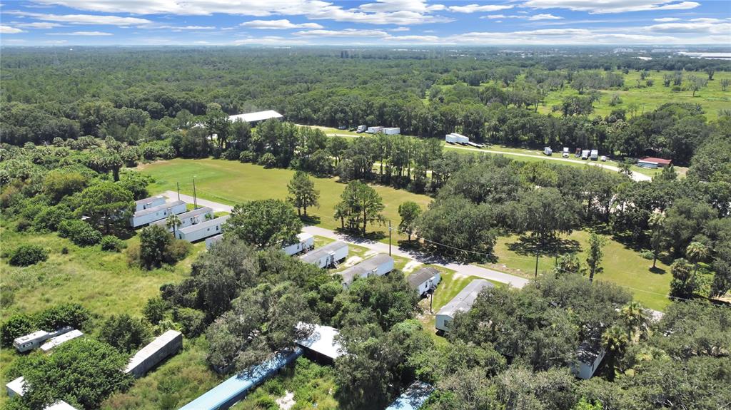 An aerial view shows several mobile homes situated on a large, wooded lot — 6304 EUGENE ACRES LANE, GIBSONTON, FL