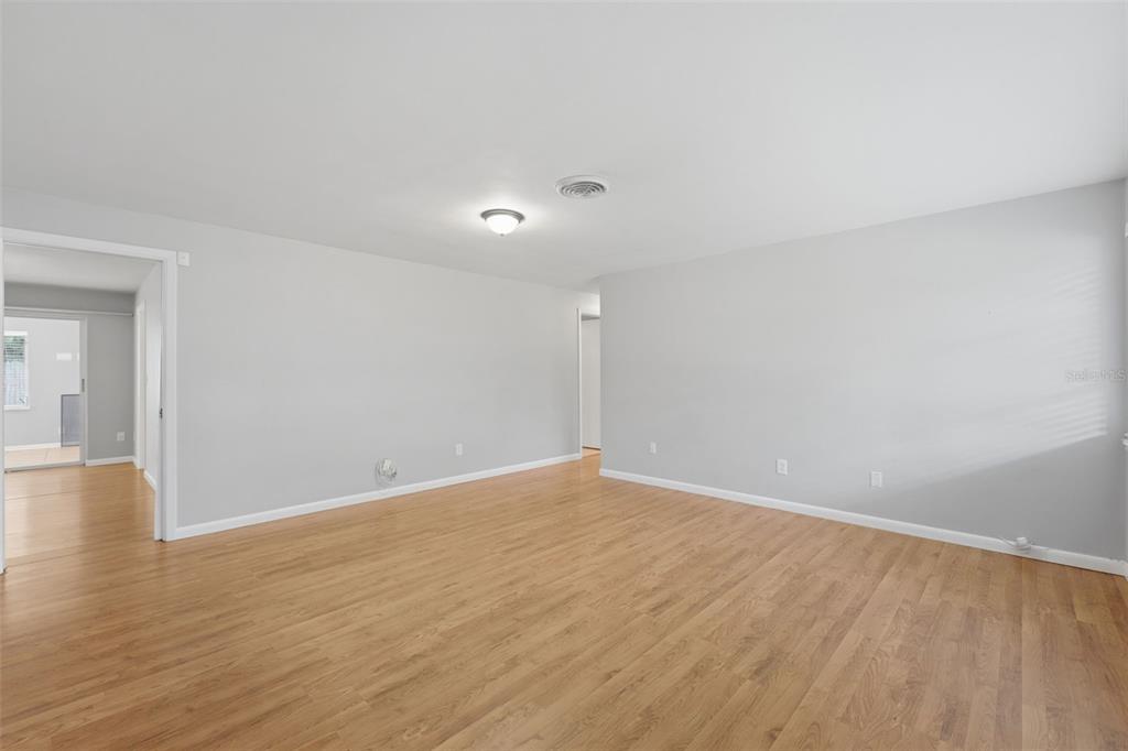 An empty room with light wood flooring, gray walls, and a ceiling light fixture — 1387 BELLEVUE BOULEVARD, CLEARWATER, FL