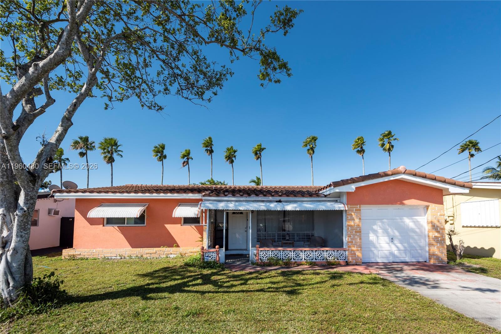 A single-story peach-colored house with a tiled roof, front porch, and attached garage — 600 SW 11th Ave, Hallandale Beach FL 33009, HALLANDALE BEACH, FL