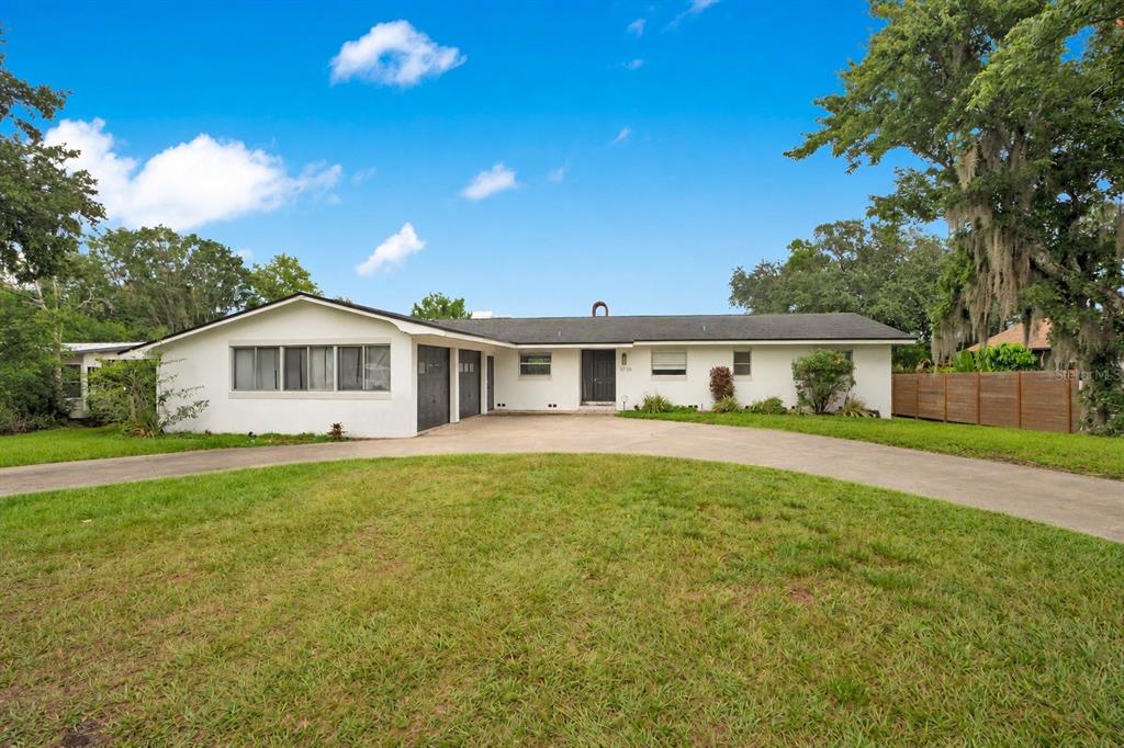 A single-story white house with a dark roof and a curved concrete driveway — 5725 PADGETT CIRCLE, ORLANDO, FL