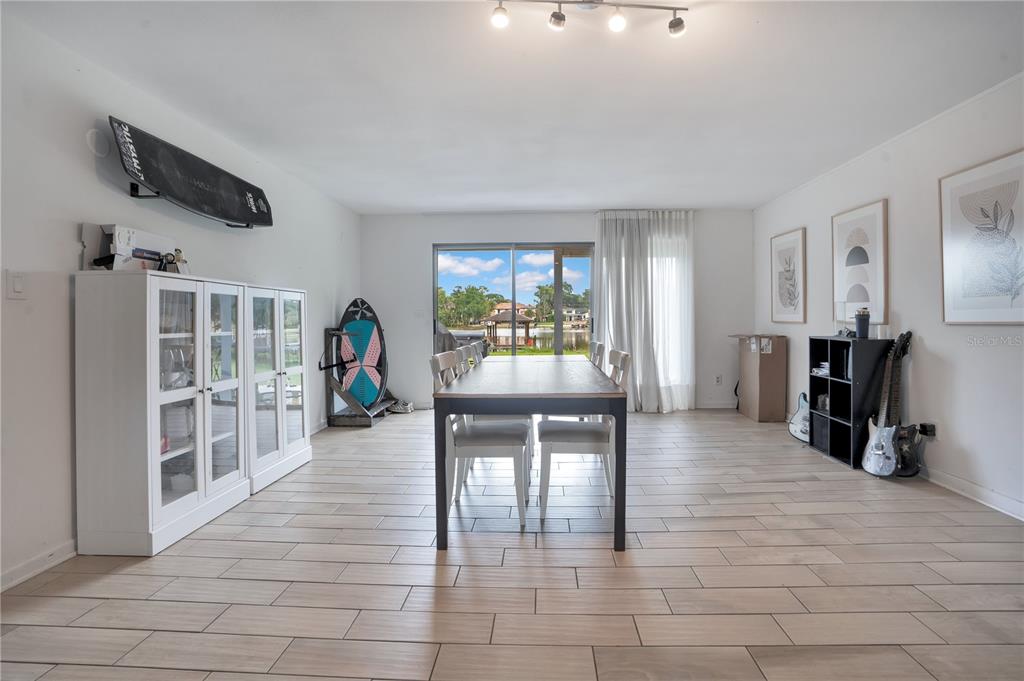 A dining room with tile flooring, a central table, and a view of a lake — 5725 PADGETT CIRCLE, ORLANDO, FL
