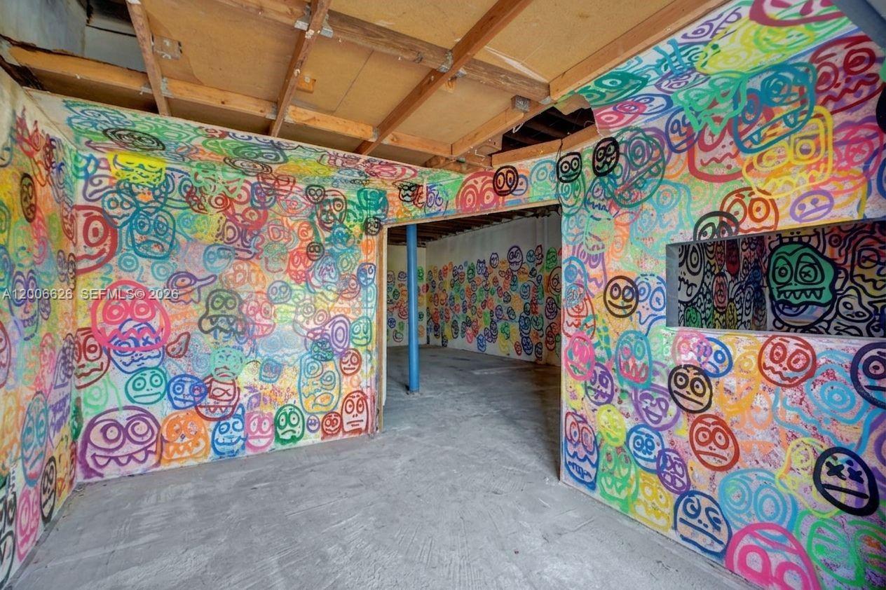 An interior room features unfinished ceilings and walls covered in colorful, hand-drawn cartoon faces — 4167 SW 18th St, West Park FL 33023, WEST PARK, FL