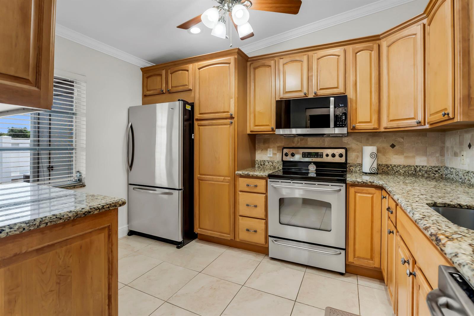 A kitchen with light wood cabinets, stainless steel appliances, and granite countertops — 18559 Egret Way, Boca Raton FL 33496, BOCA RATON, FL