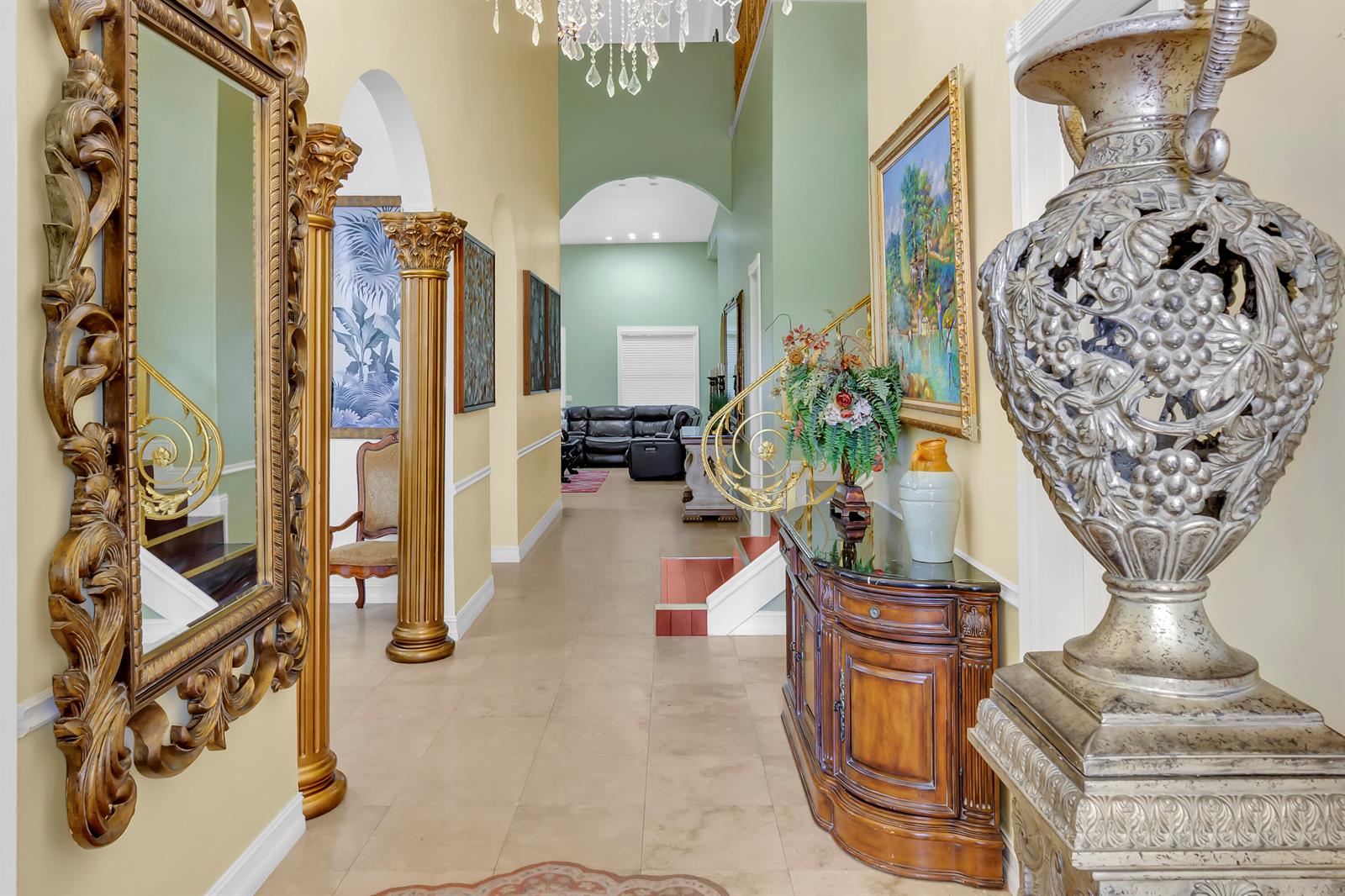 A grand foyer features a large ornate mirror, gold columns, and a decorative silver urn — 12121 70th Place N, FL 33412, FL