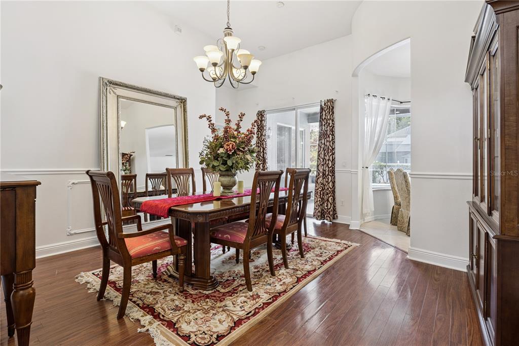 A formal dining room features a wooden table, chairs, a large mirror, and hardwood floors — 710 REGINA CIRCLE, OAKLAND, FL