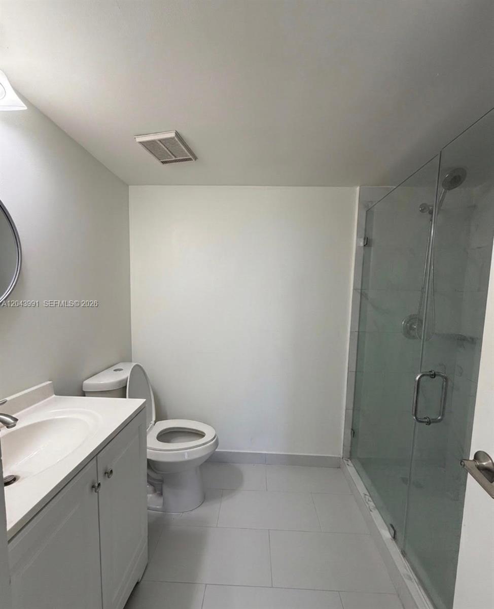 A bathroom features a white vanity, a toilet, and a glass-enclosed walk-in shower — 2055 SW 122nd Ave # 327, Miami FL 33175, MIAMI, FL
