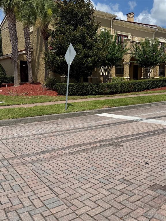 A paved street leads to a multi-story building with palm trees and landscaping — 2404 BELLA VISTA DRIVE, DAVENPORT, FL