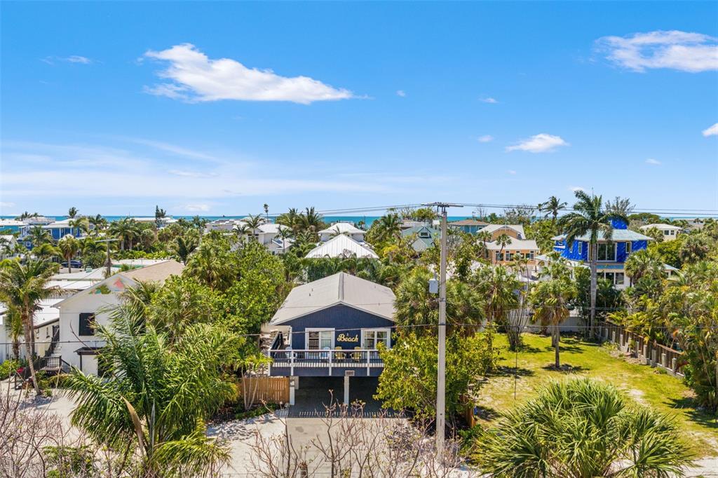 A white plastic chair sits on a gravel patch next to a wooden boat dock — 8106 GULF DRIVE UNIT A&B, HOLMES BEACH, FL