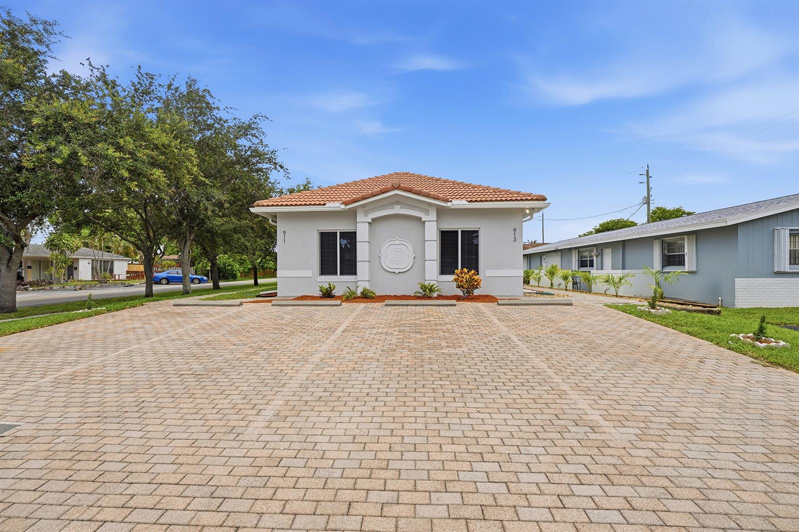A single-story building with a tiled roof and a large paved parking area in front — 911 NE 12th Avenue, Pompano Beach FL 33060, POMPANO BEACH, FL