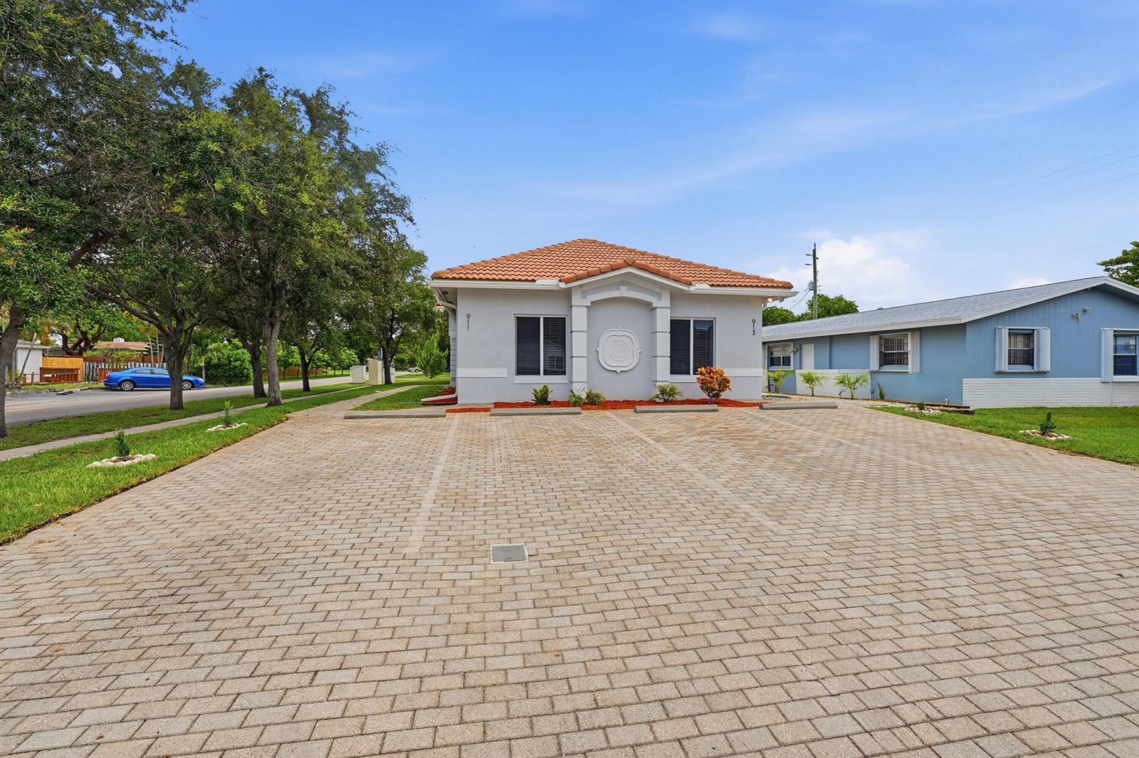 A single-story house with a tiled roof and a large paved parking area in front — 911 NE 12th Avenue, Pompano Beach FL 33060, POMPANO BEACH, FL