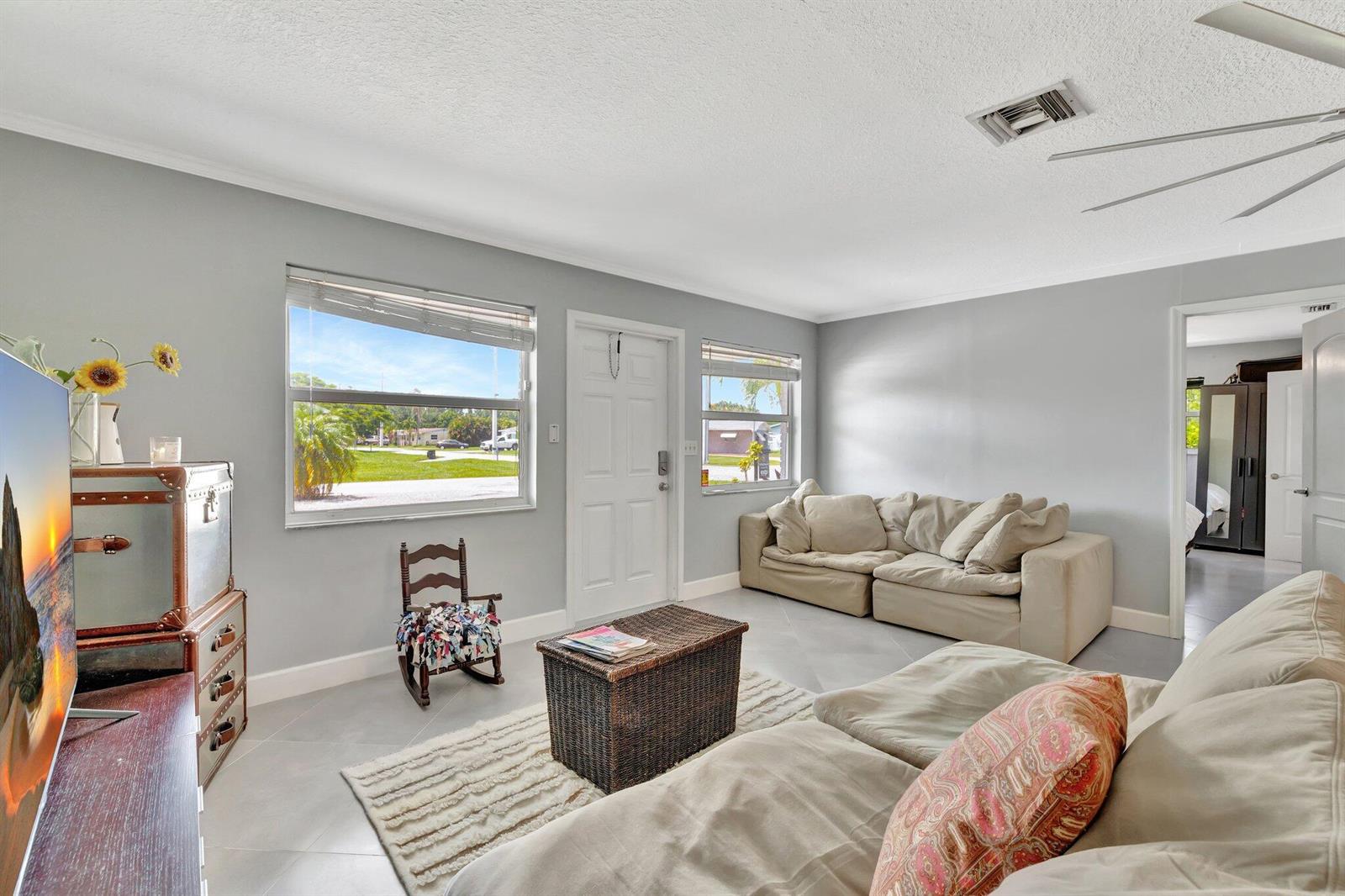 A living room features light gray walls, tile flooring, two beige sofas, and a front door — 1894 SE Lafayette Street, Stuart FL 34997, STUART, FL