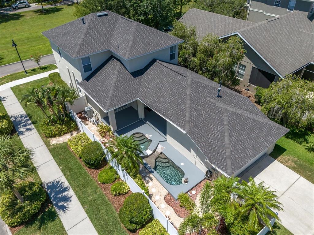 An aerial view shows a two-story house with a small pool and spa in the backyard — 10121 PORCH STREET, NEW PORT RICHEY, FL