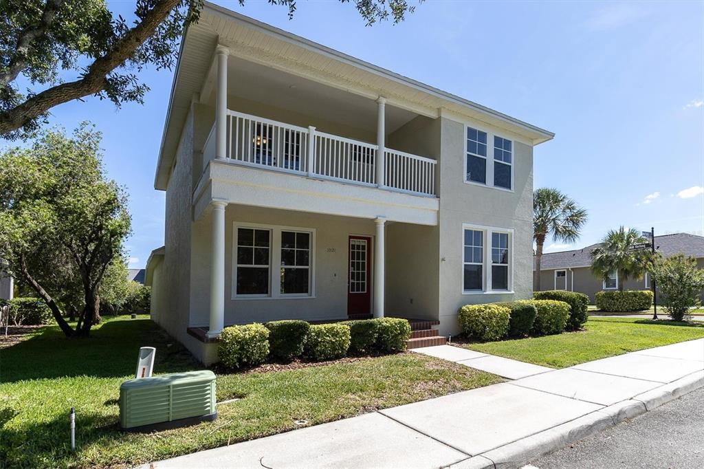 A two-story house with a front porch, balcony, and a red front door — 10121 PORCH STREET, NEW PORT RICHEY, FL