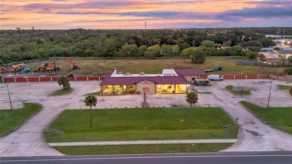 An aerial view of a commercial building with a large parking lot and surrounding land — 1552 W KING STREET, COCOA, FL