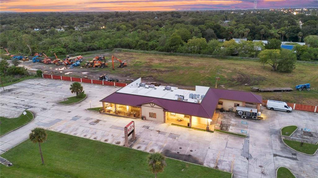 An aerial view shows a commercial building with a parking lot and construction equipment nearby — 1552 W KING STREET, COCOA, FL
