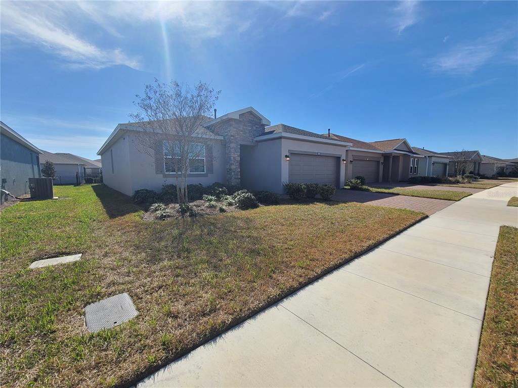 A single-story suburban house with a stone facade, two-car garage, and a paved driveway — 5380 NW 43RD LANE ROAD, OCALA, FL