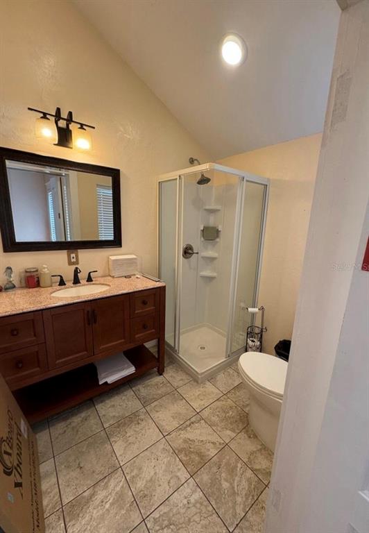 A bathroom features a wood vanity, a corner glass shower, and tiled flooring — 318 PALMETTO STREET, NEW SMYRNA BEACH, FL