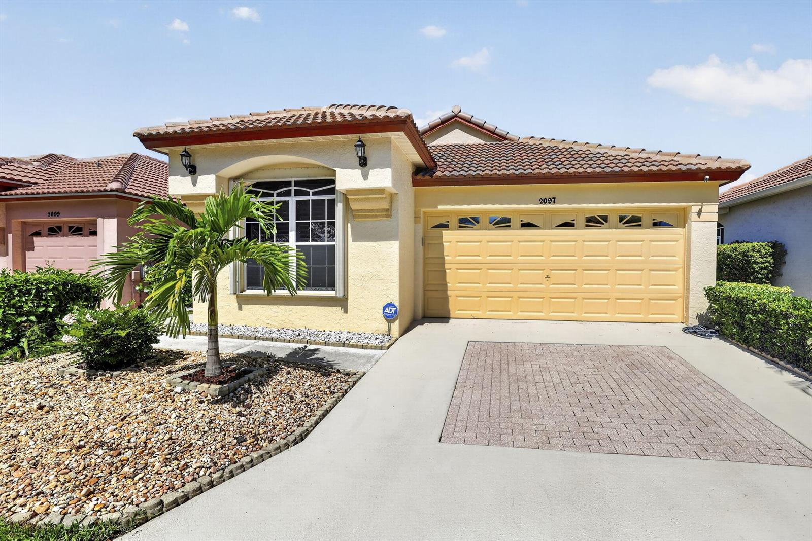 A screened-in patio overlooks a grassy lawn and a small lake with a fountain — 2097 Bonisle Circle, Riviera Beach FL 33418, RIVIERA BEACH, FL
