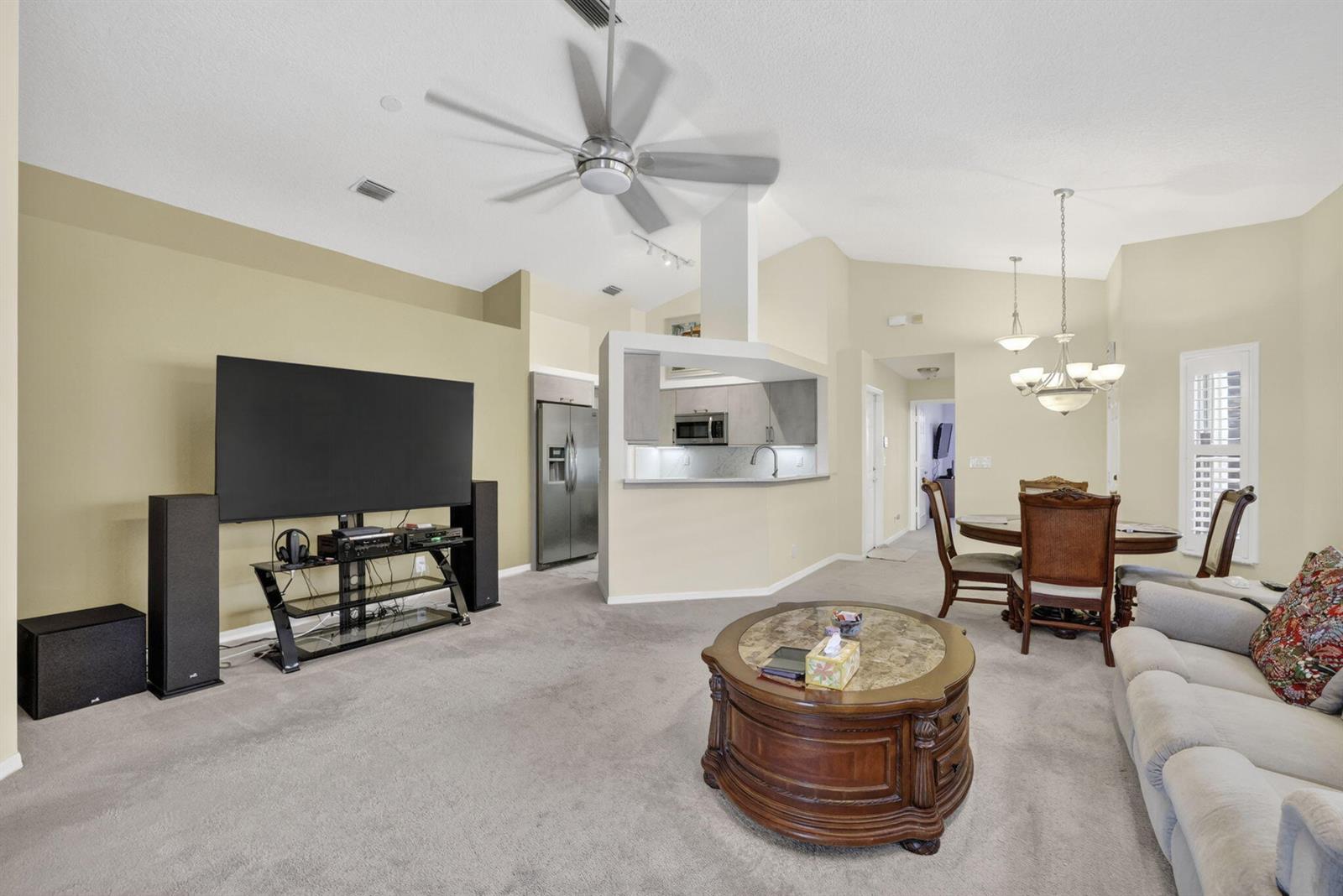 A single-story house with a beige stucco exterior, a tile roof, and a two-car garage — 2097 Bonisle Circle, Riviera Beach FL 33418, RIVIERA BEACH, FL