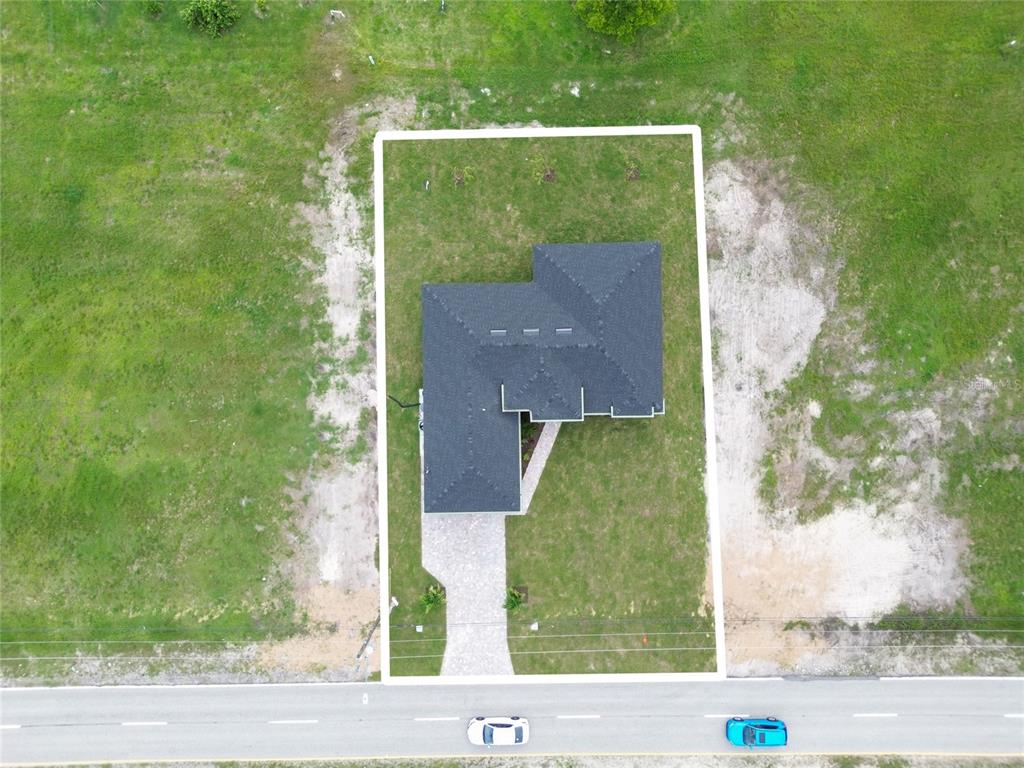 An aerial view shows a single-story house with a dark roof on a rectangular lot — 2720 SANTA BARBARA BOULEVARD N, CAPE CORAL, FL