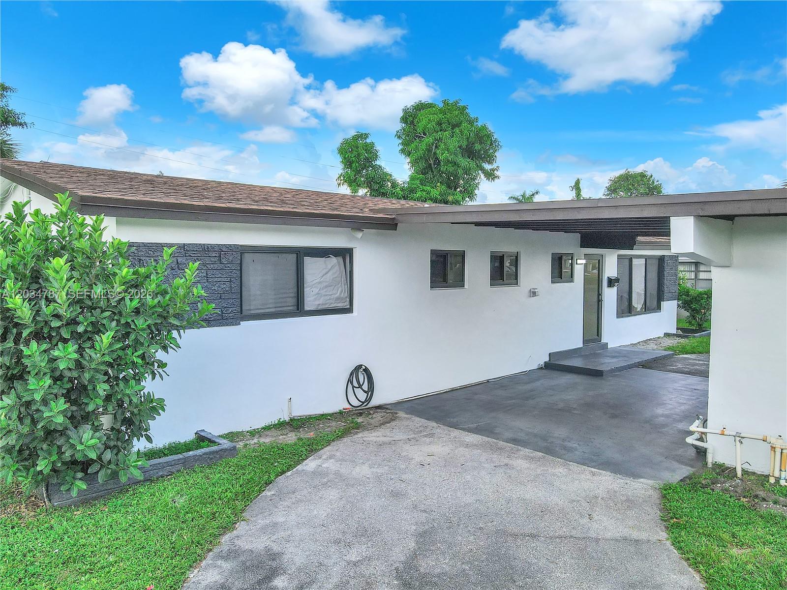 A white single-story house with a carport, a concrete driveway, and a small front lawn — 3810 NW 6th St, Lauderhill FL 33311, LAUDERHILL, FL