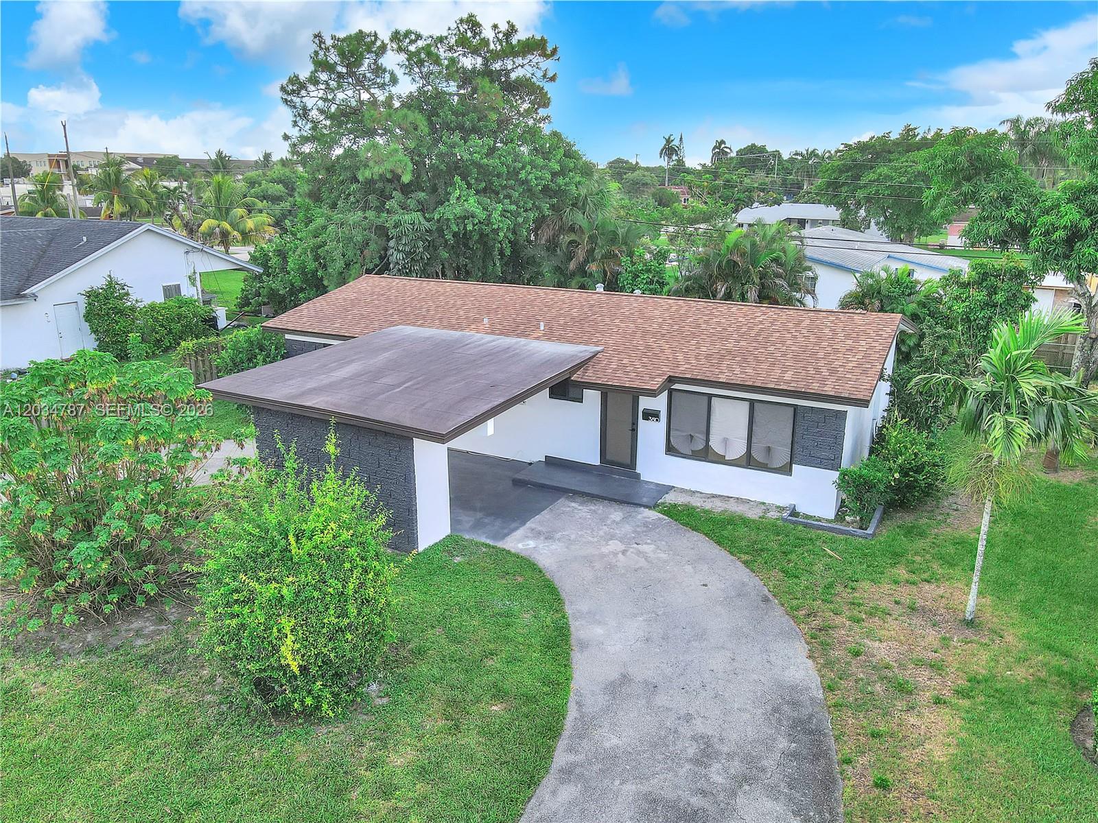 An aerial view of a single-story house with a carport and a curved driveway — 3810 NW 6th St, Lauderhill FL 33311, LAUDERHILL, FL