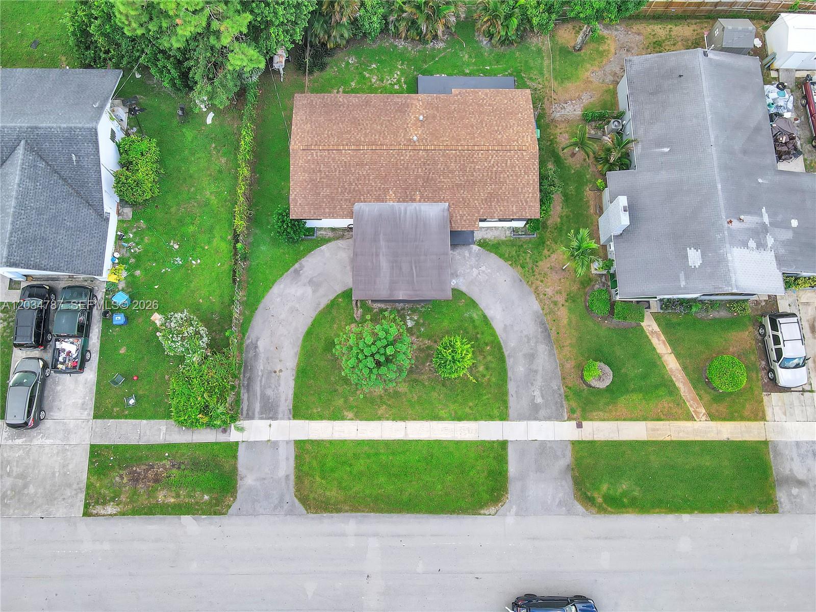 An aerial view shows a house with a U-shaped driveway and a brown shingled roof — 3810 NW 6th St, Lauderhill FL 33311, LAUDERHILL, FL