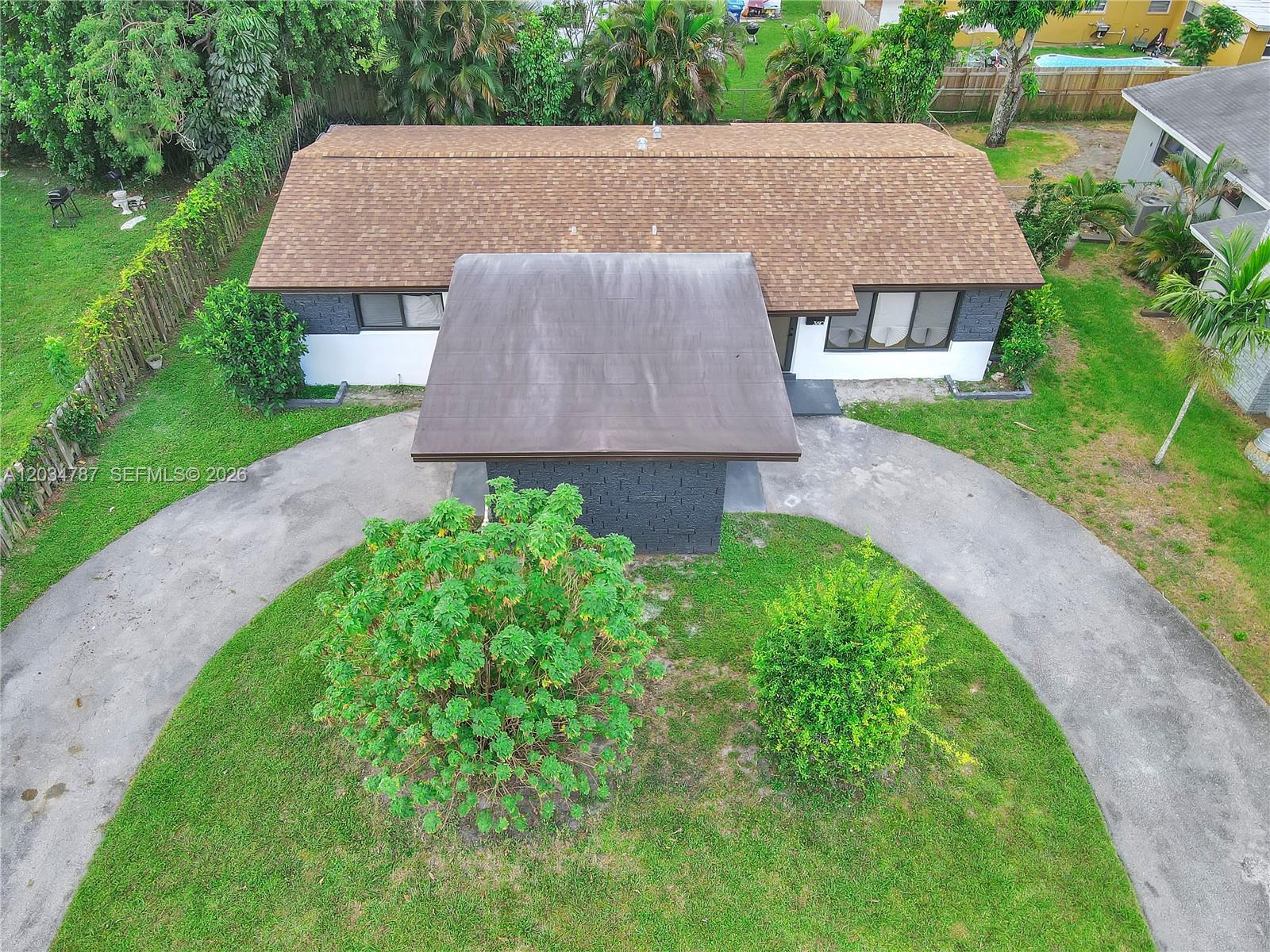 An aerial view shows a single-story house with a brown roof and a circular driveway — 3810 NW 6th St, Lauderhill FL 33311, LAUDERHILL, FL