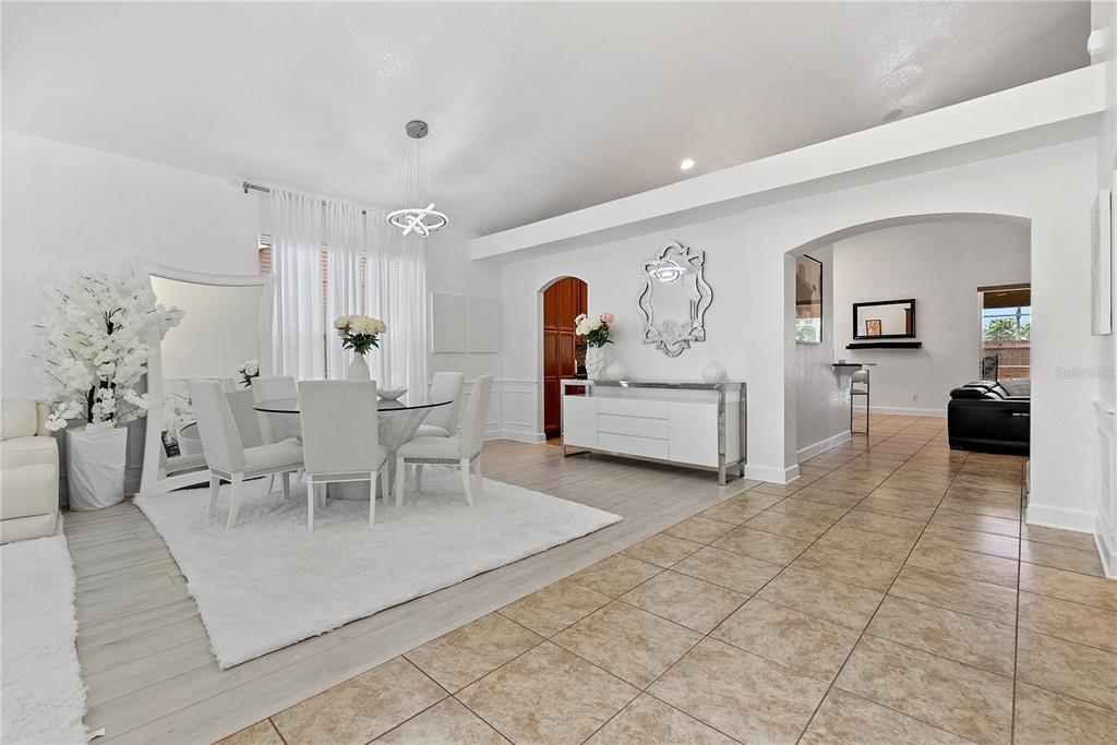 A dining area with a glass table, white chairs, and a rug on tiled flooring — 446 ANESSA ROSE LOOP, OCOEE, FL