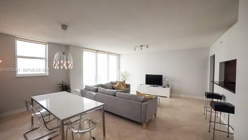 A living and dining area features a gray sectional sofa, dining table, and bar seating — 31 SE 5th St # 2001, Miami FL 33131, MIAMI, FL