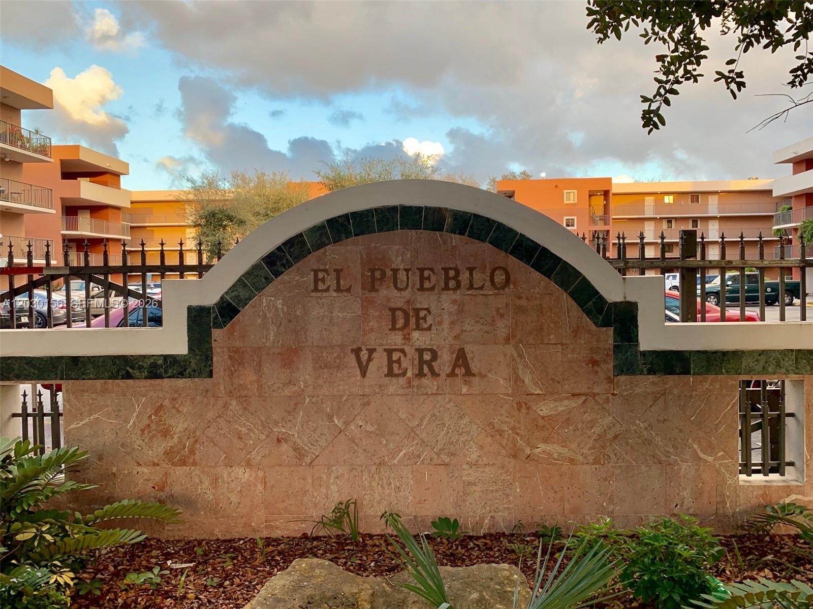 A stone monument sign for El Pueblo De Vera stands before a multi-story apartment complex — 5825 W 25th Ct # 311, Hialeah FL 33016, HIALEAH, FL