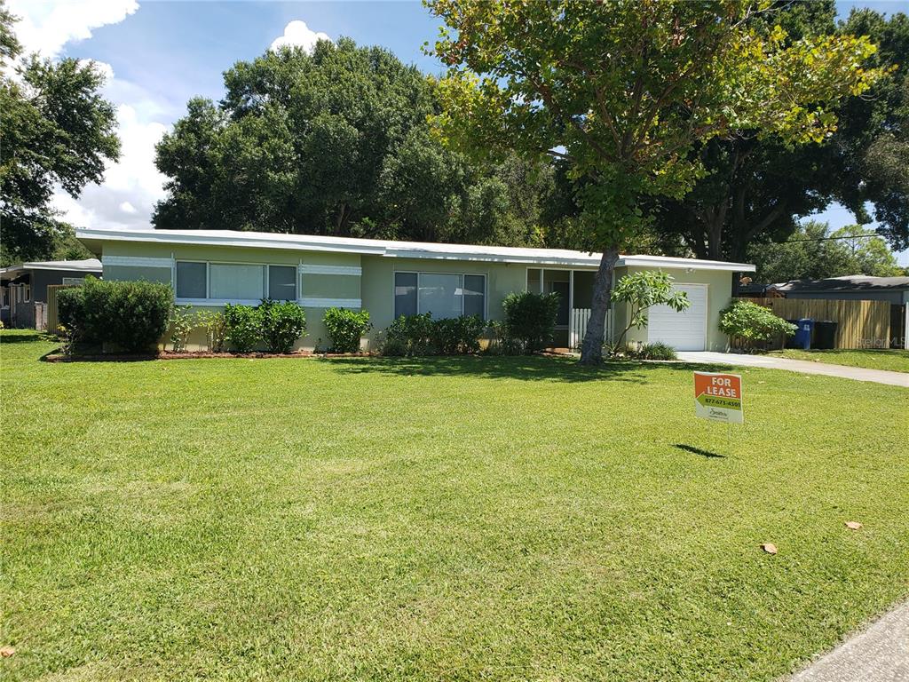 A single-story house with a light green exterior, a front lawn, and a for-lease sign — 7475 19TH AVENUE N, ST PETERSBURG, FL