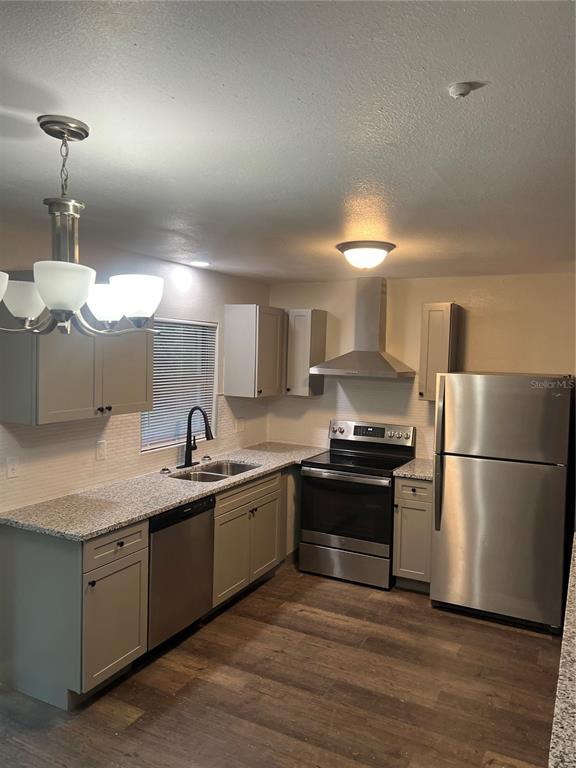 A kitchen features light gray cabinets, granite countertops, stainless steel appliances, and wood-look flooring — 1606 NW 20TH COURT, OCALA, FL