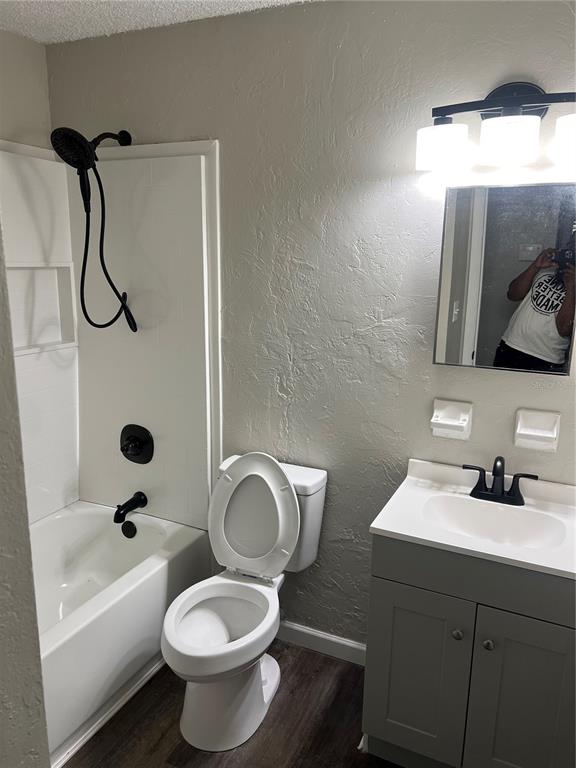 A bathroom features a white tub-shower combo, a toilet, and a gray vanity with black fixtures — 1606 NW 20TH COURT, OCALA, FL