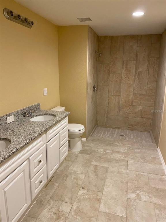 A bathroom features a granite-topped double vanity, a tiled walk-in shower, and beige walls — 4300 W HIGHWAY 316, REDDICK, FL