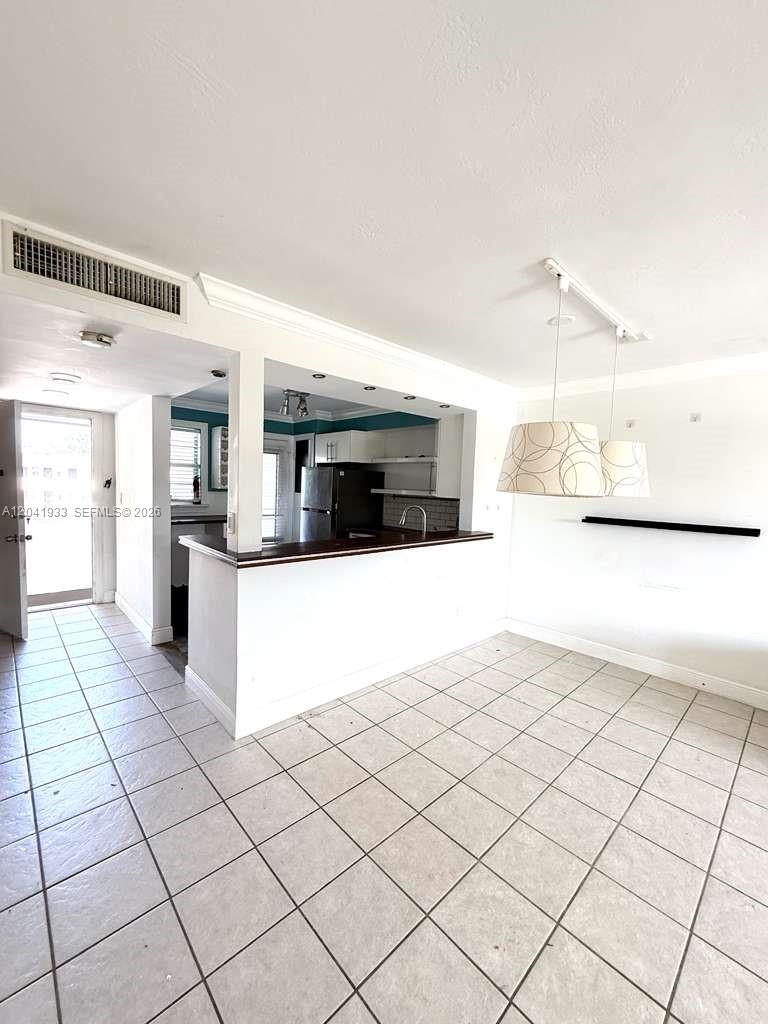 This room features a tiled floor, a breakfast bar, and two hanging pendant lights — 1530 NE 191st St # 340, Miami FL 33179, MIAMI, FL