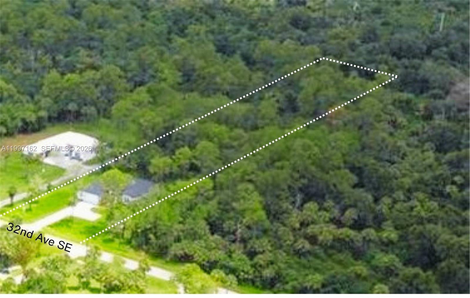 An aerial view shows a rectangular plot of land outlined in white amidst dense forest — 3762 32nd AVE SE, Naples FL 34117, NAPLES, FL